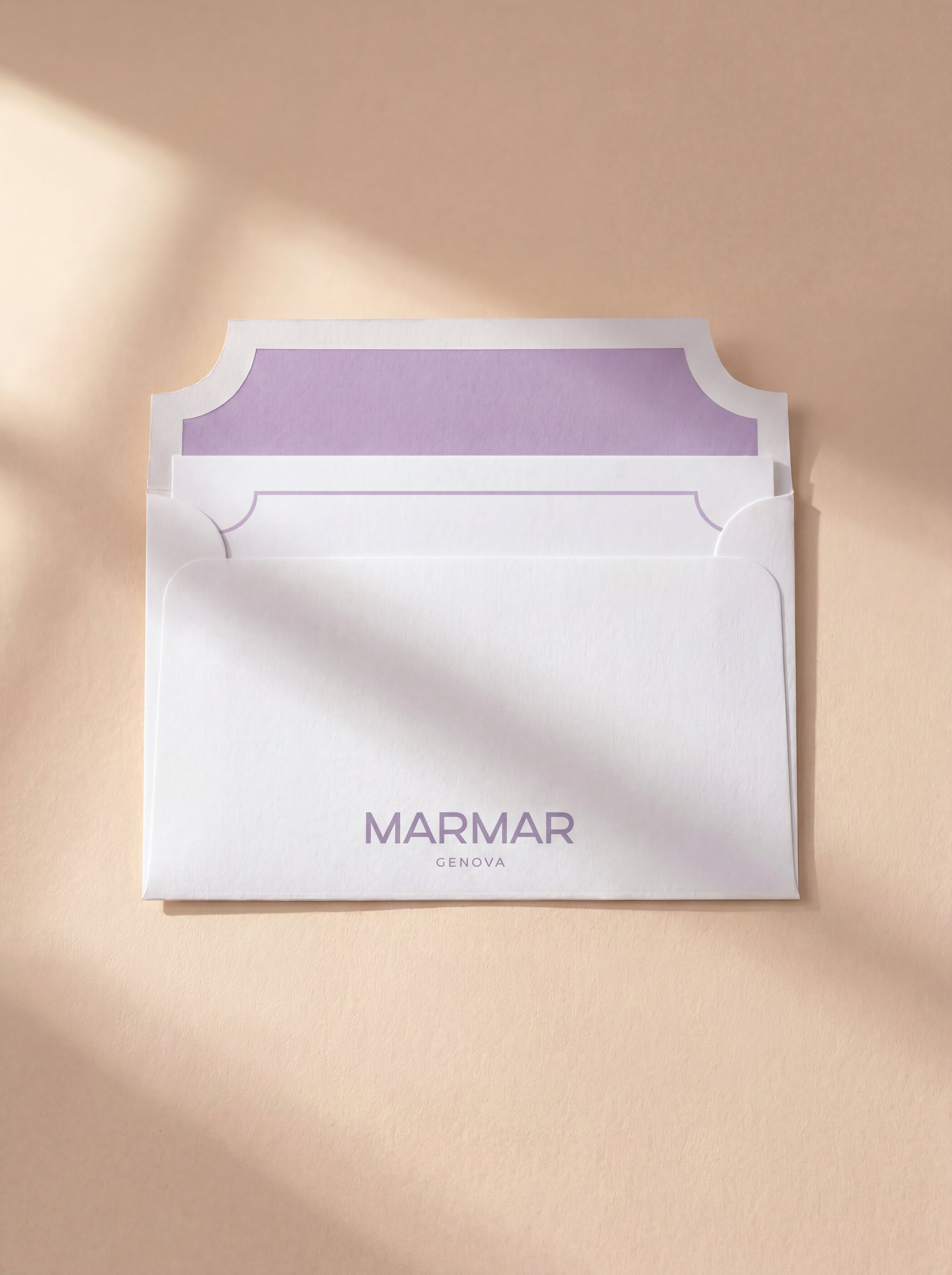 Topshot visual of a white and lilac MarMar envelope with a card peaking out