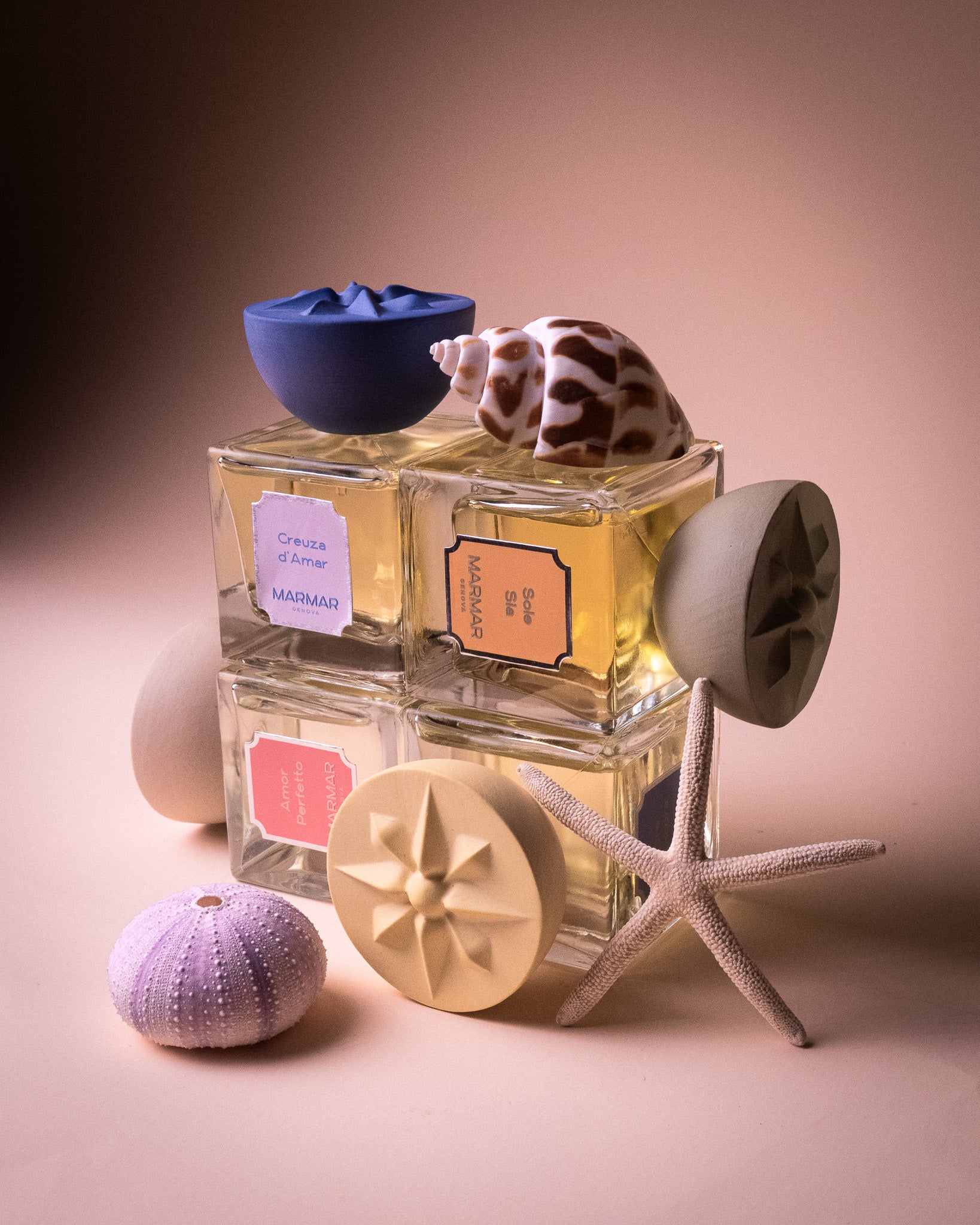 Still life of the MarMar Genova Eau de Parfum collection shot in a studio setting with colorful seashells and starfish
